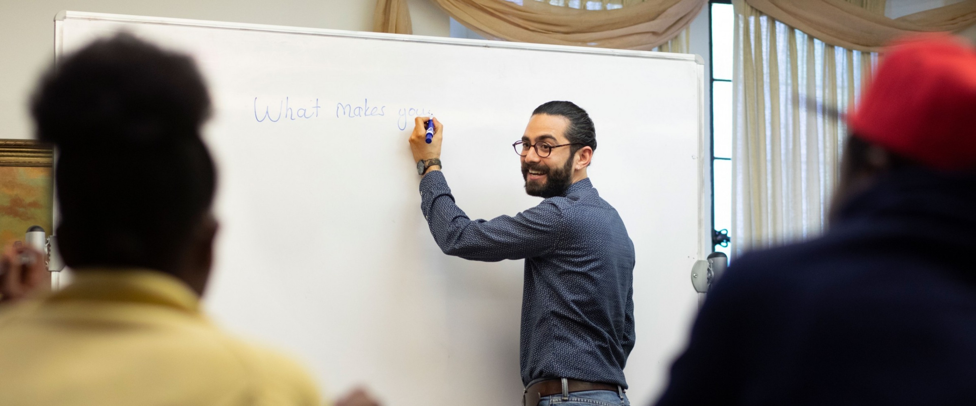 WMU graduate Deniz Toker teaching a lesson in front of a classroom of students