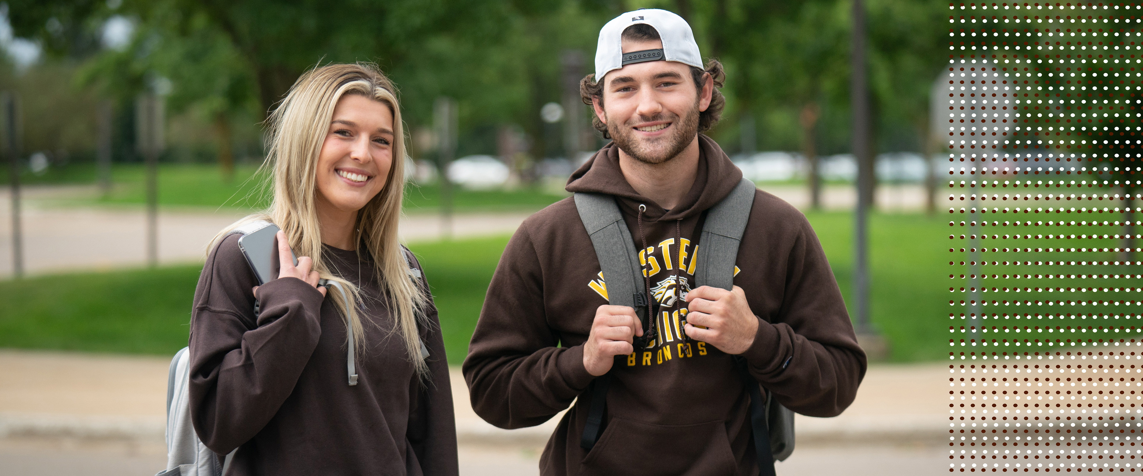 Two business students stand outside of the Haworth College of Business.