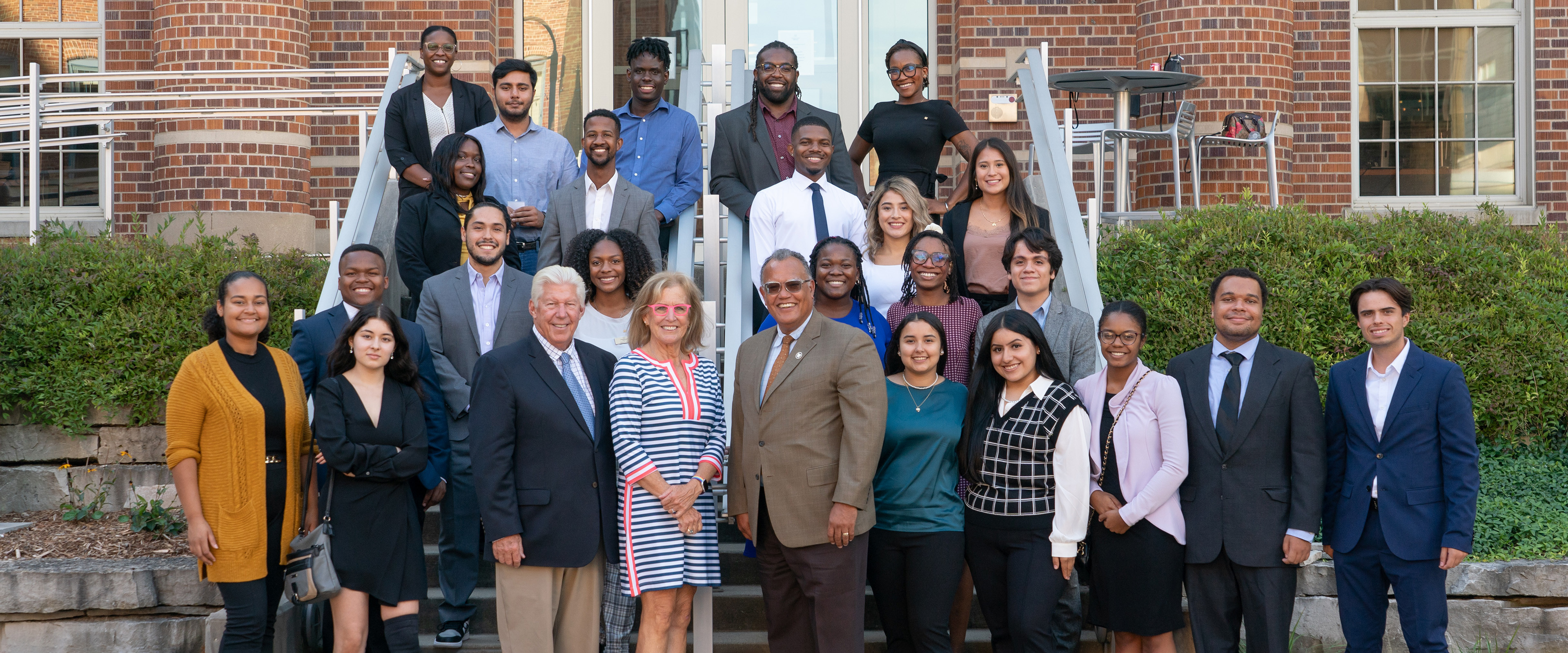 Current and former Greenleaf Trust Scholars stand outside of the Greenleaf Trust office in Downtown Kalamazoo with President Edward Montgomery.
