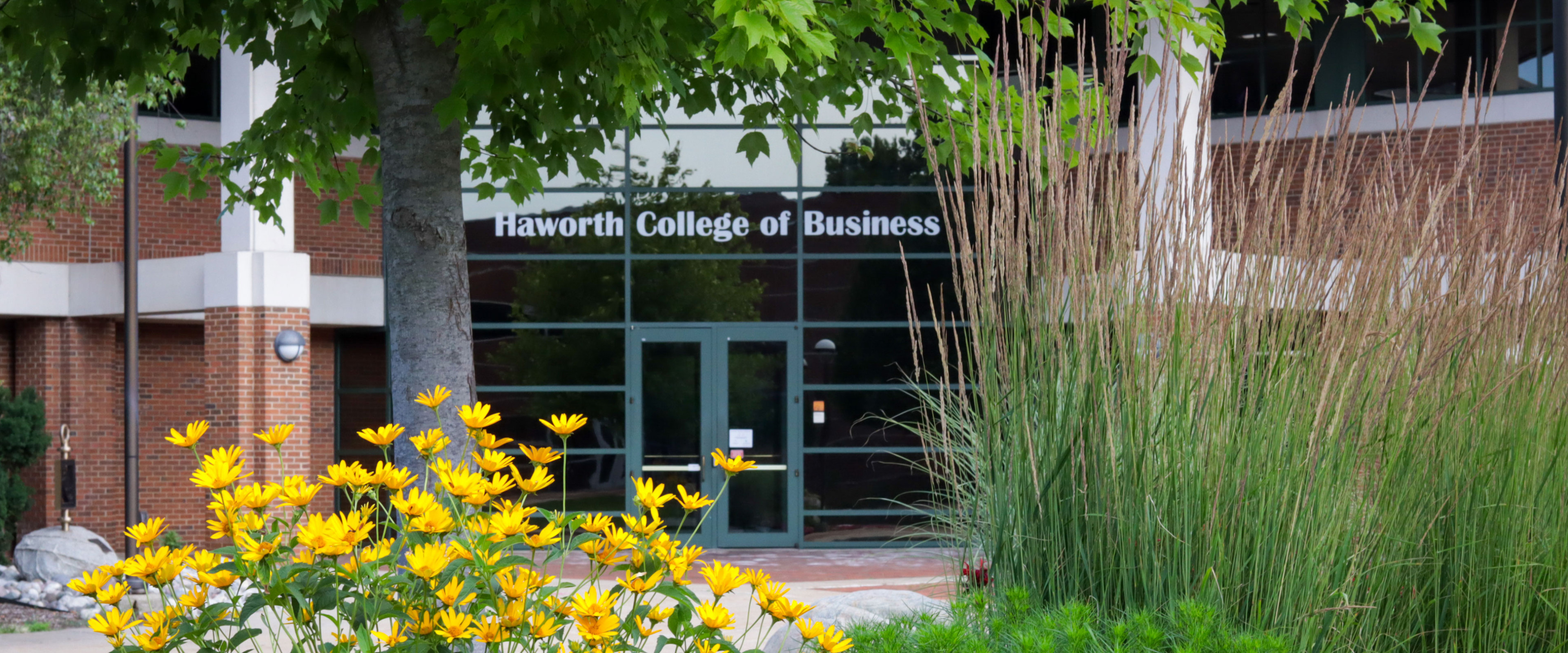 Photo of door to Haworth College of Business with flowers blooming.