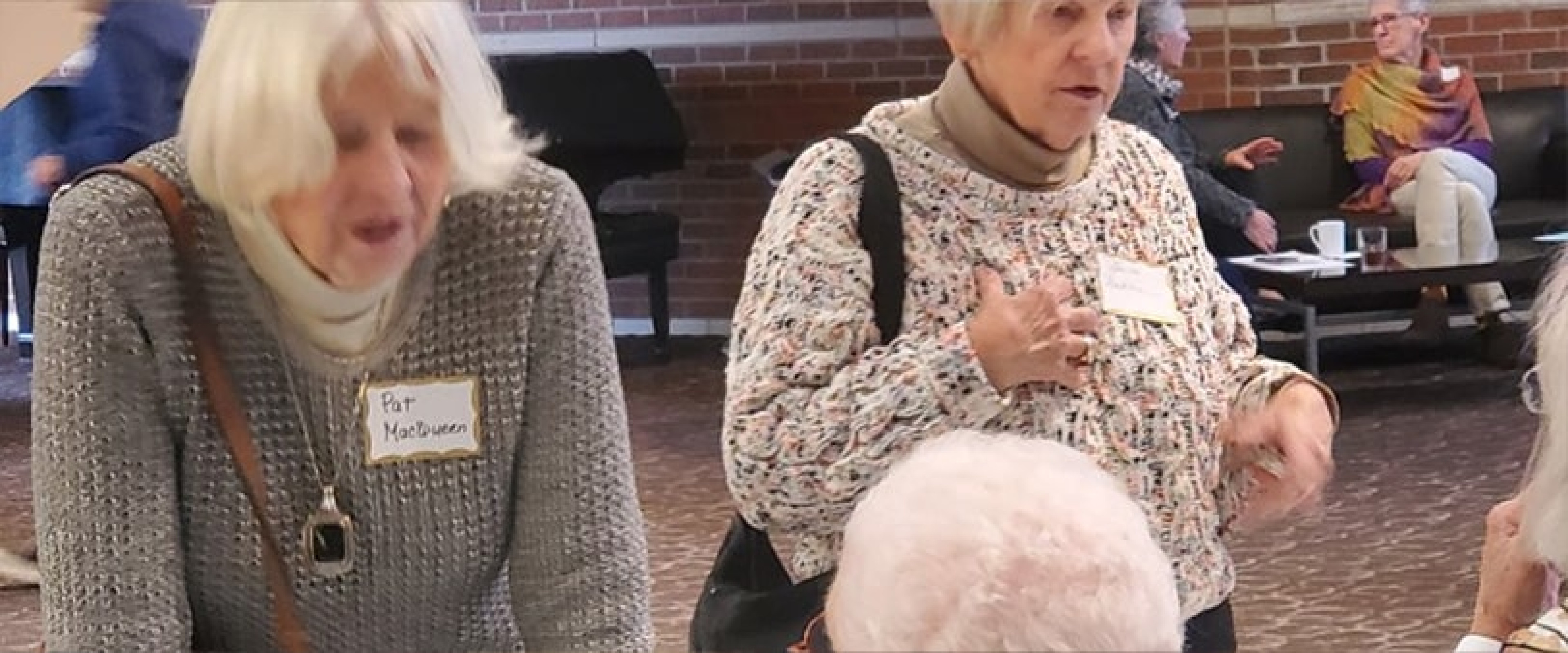 Two ladies mid discussion during the OLLI event.