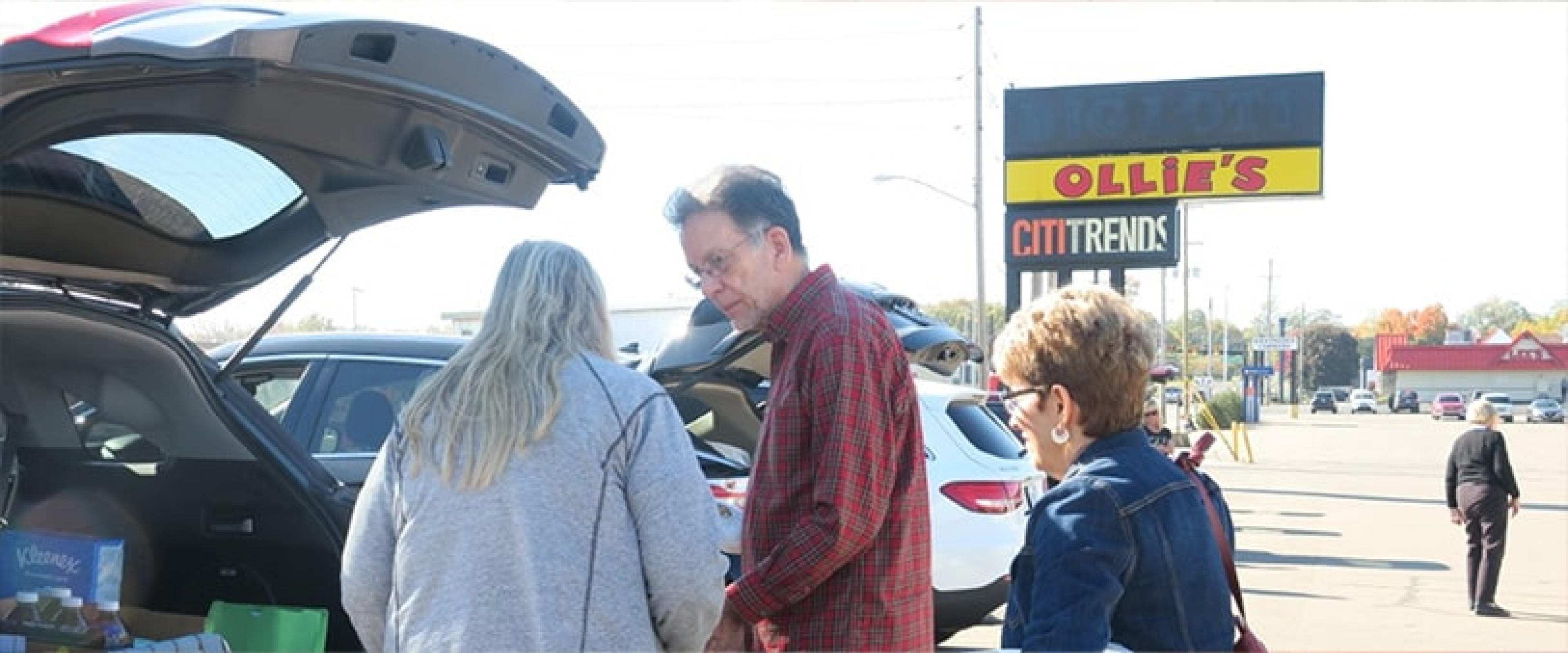 OLLI members helping load donations into the back of a car.