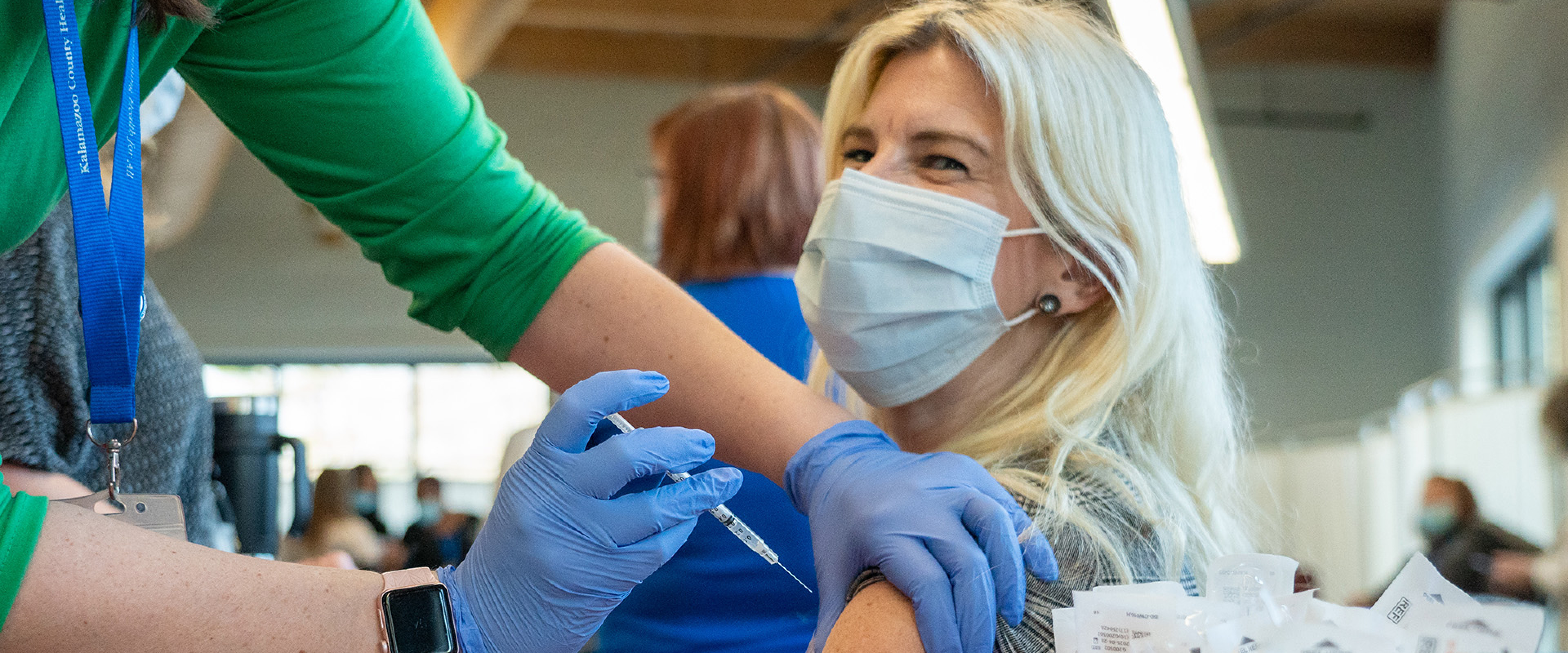 Dr. Ruggiero getting vaccinated in the upper arm by a Kalamazoo County nurse.