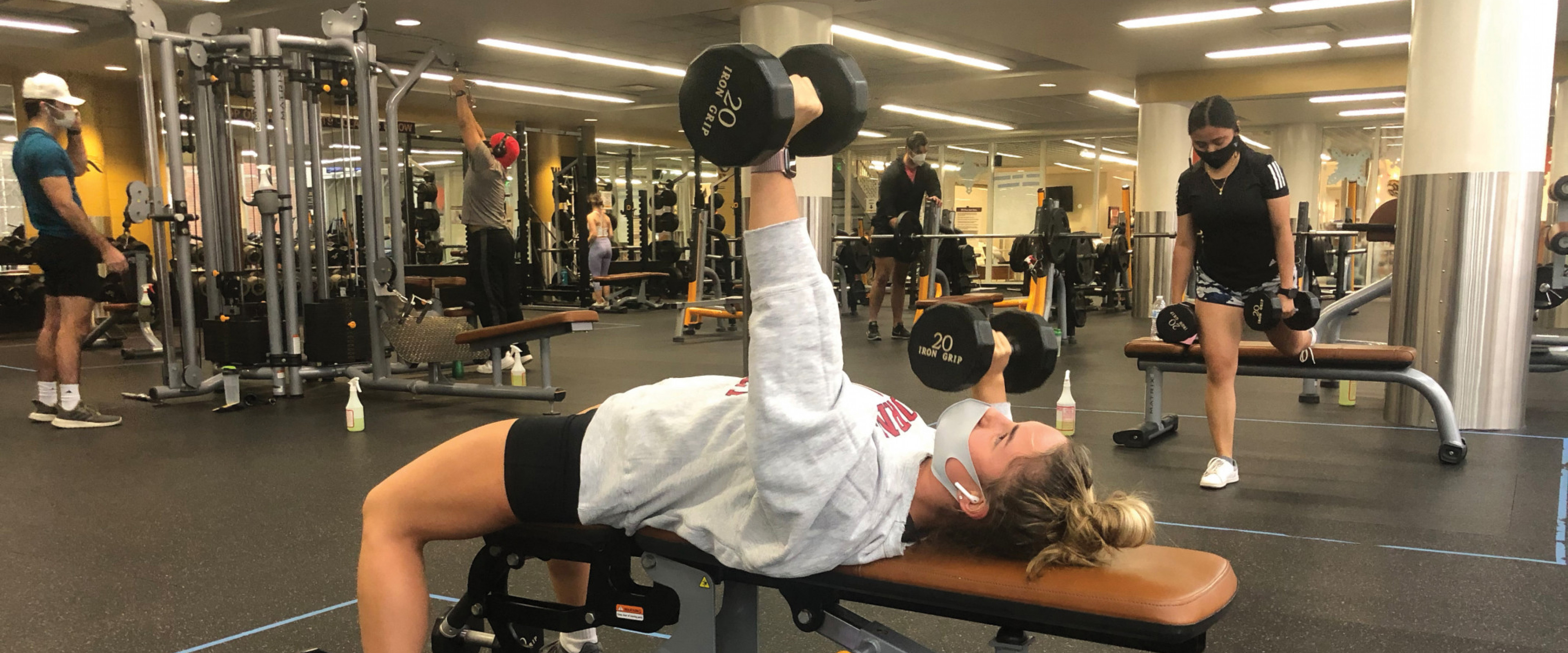 Participants working out in the weight room with masks on at the SRC