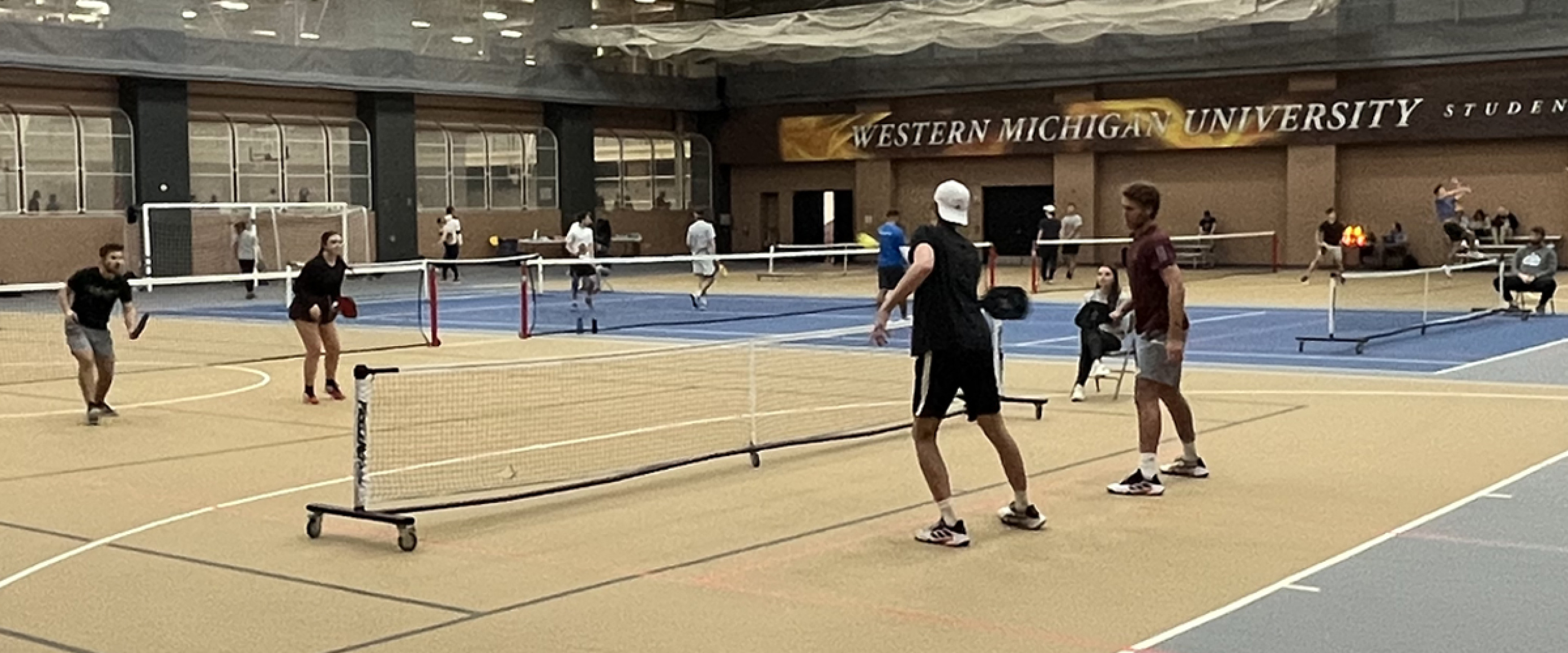Group of people playing pickleball with a net