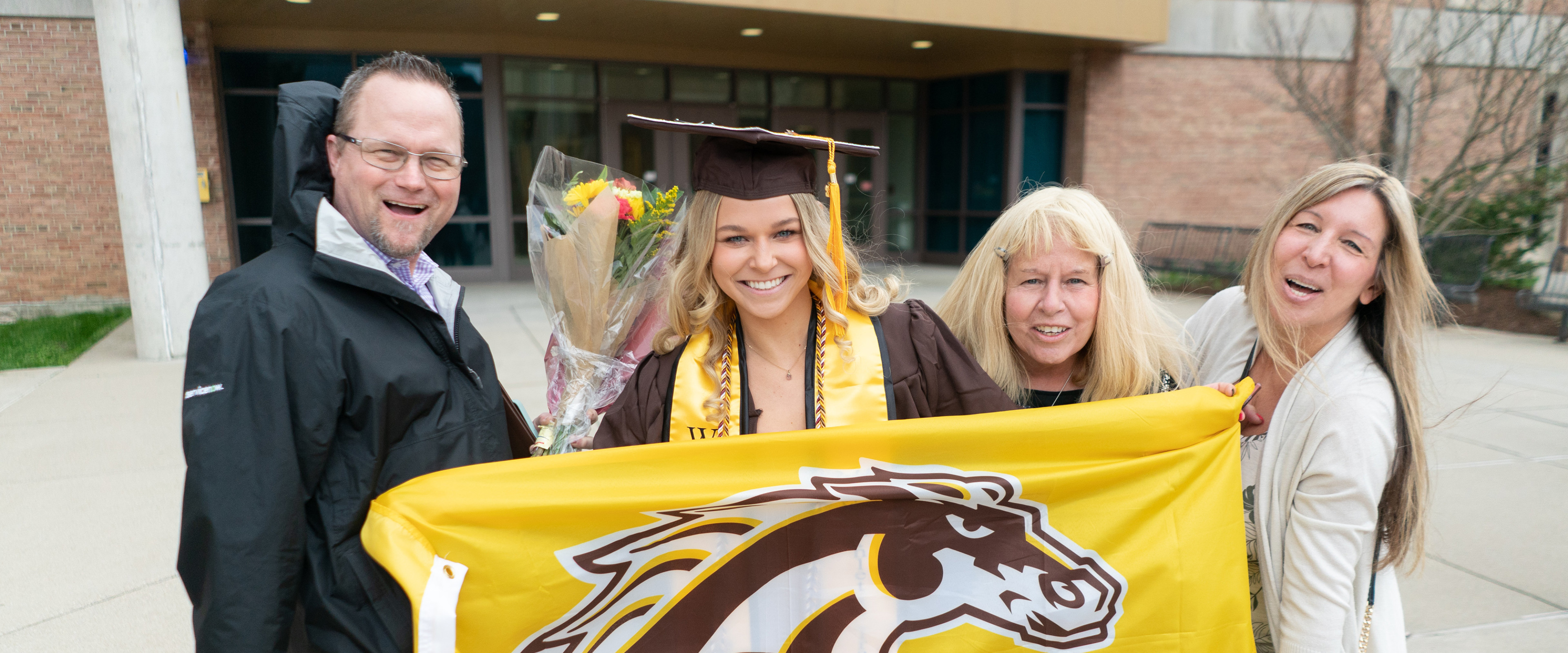 Student with family at graduation