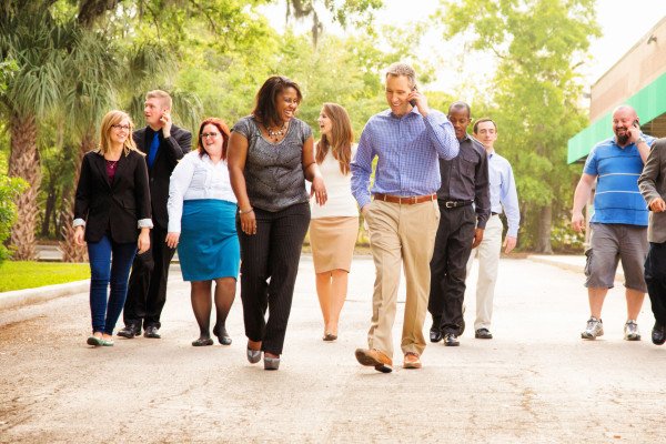 Diverse group of people dressed in business casual clothes walking outside