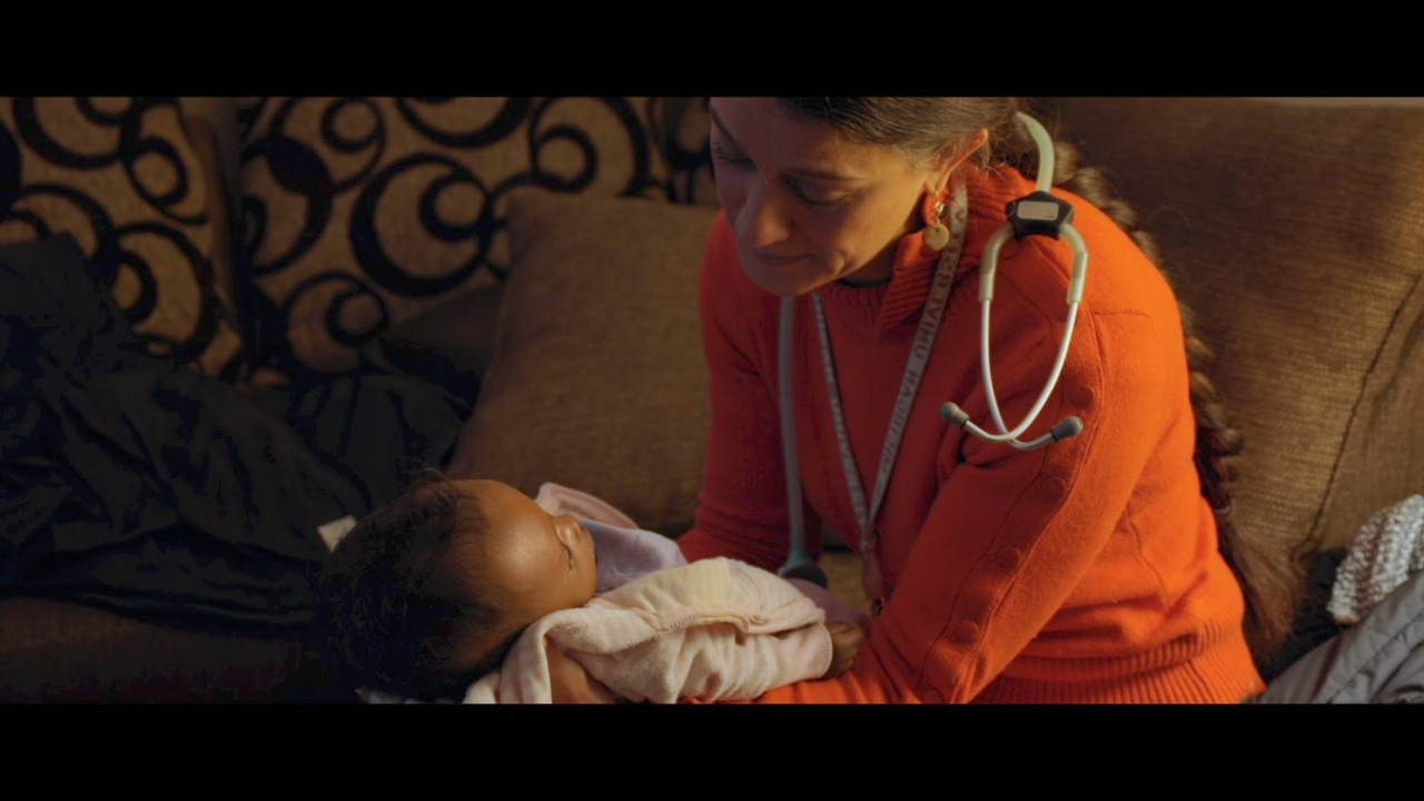 Dr. Nadia Tremonti holds a small baby. 