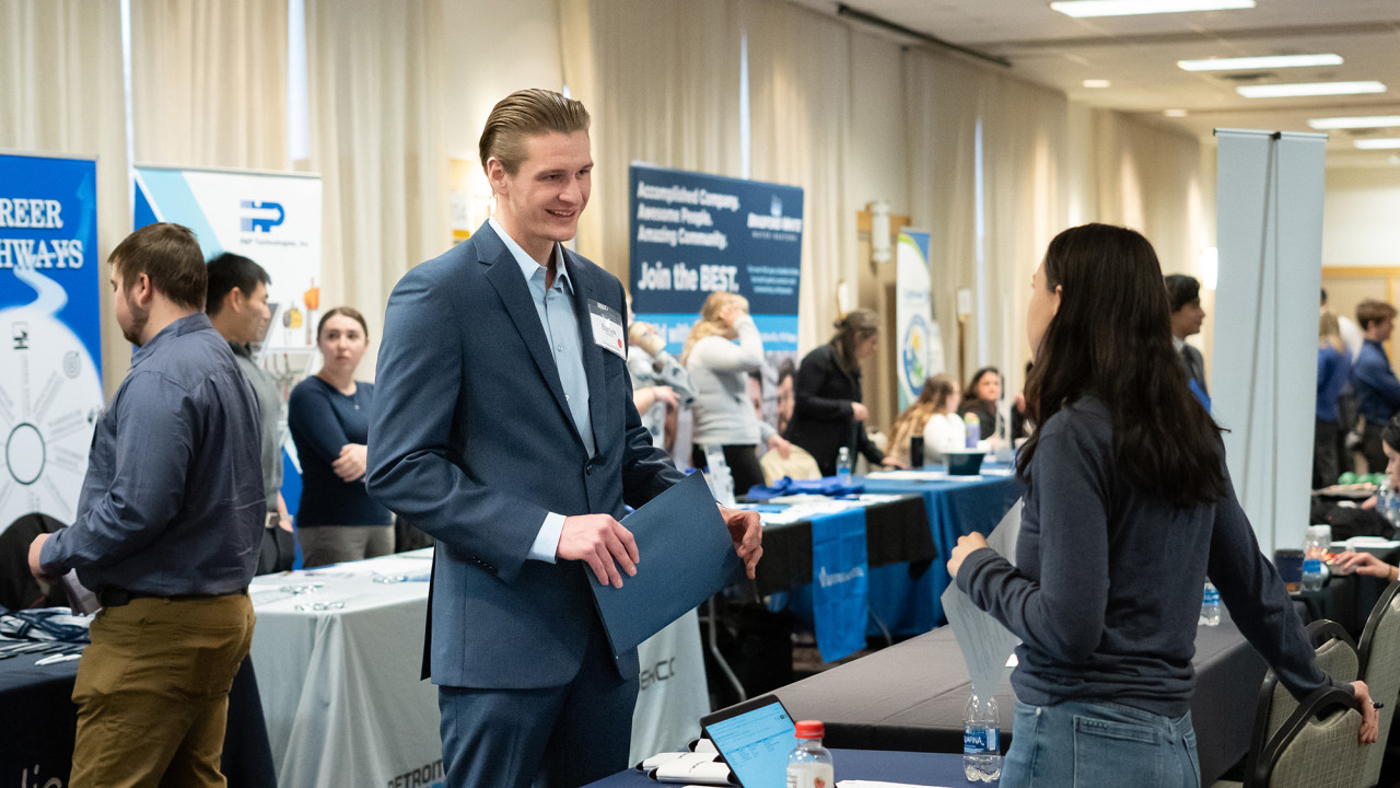 A student is talking to a job recruiter at an event.