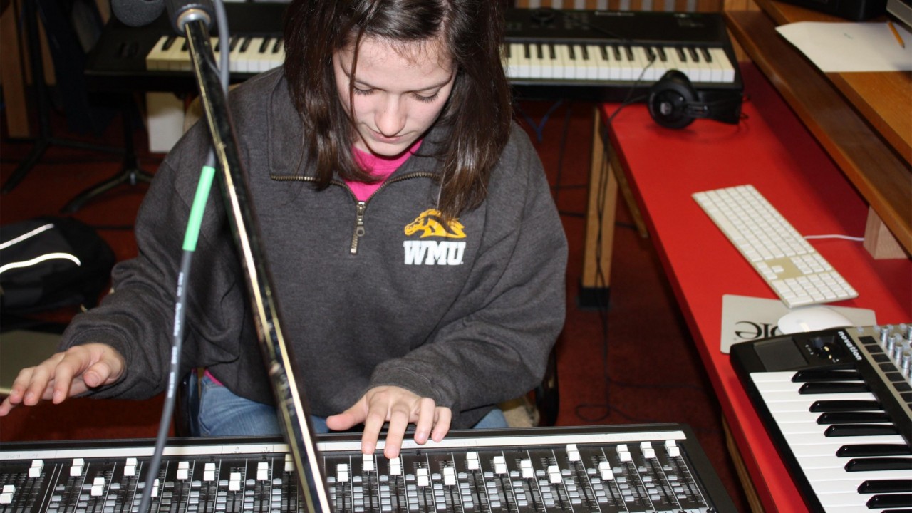 Photo of a girl using a sound mixing board.