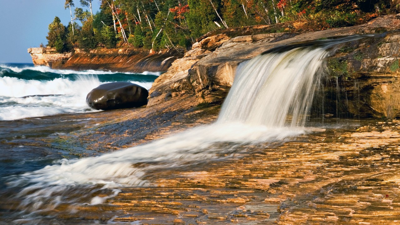 A Lake Michigan waterfall empties over a bed of rocks