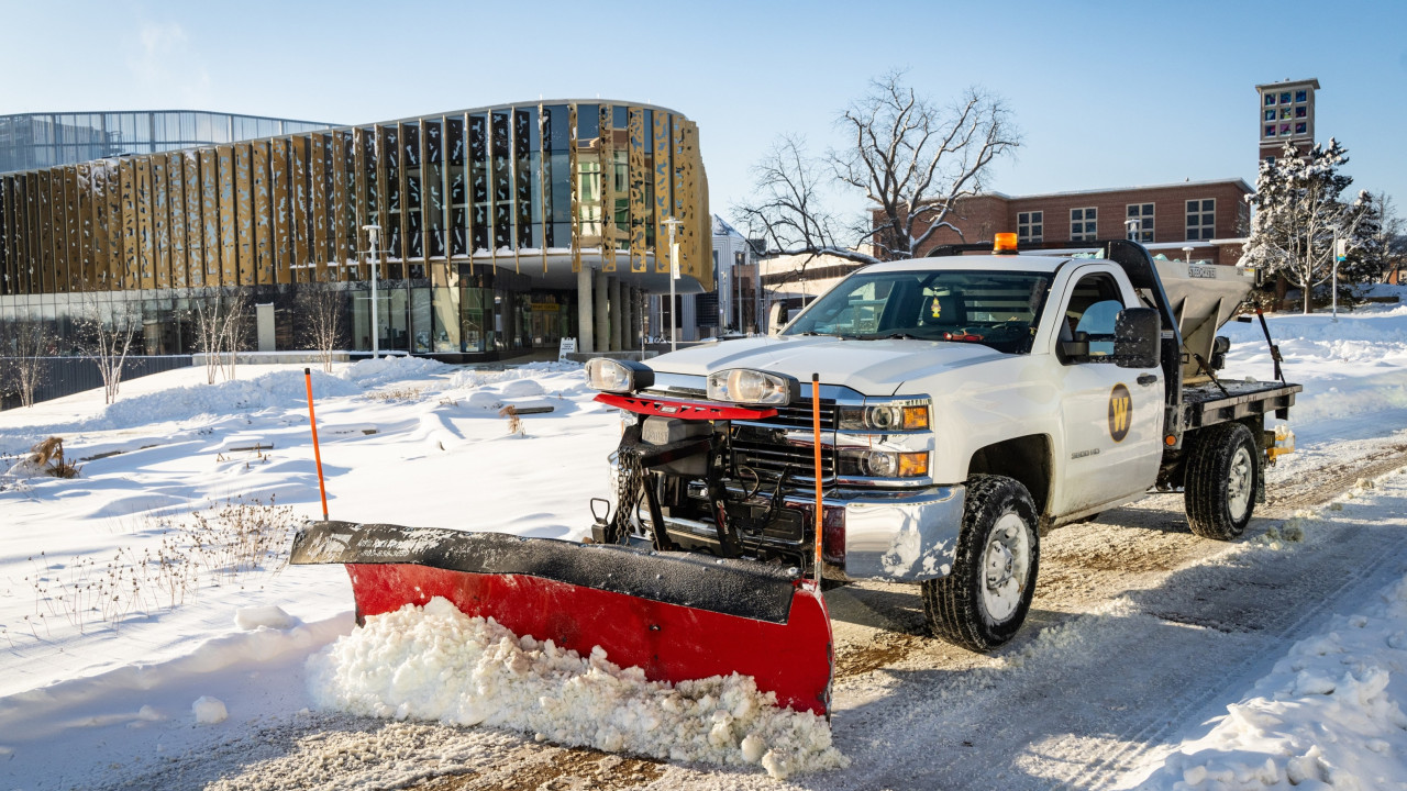 A Landscape Services snowplow is seen in action, plowing snow in front of the Student Center.
