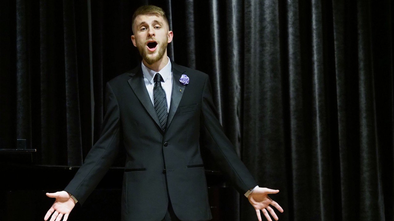 young man singing in a suit