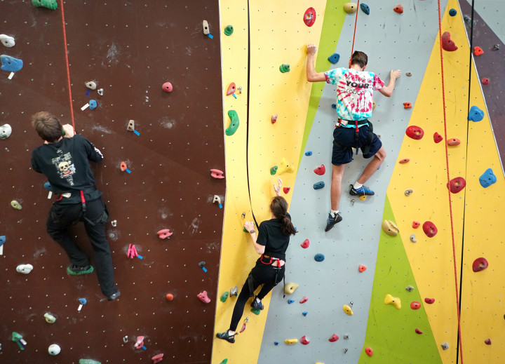 students at the rec center on the climbing wall.