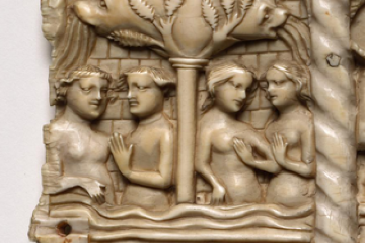 A fourteenth-century carved ivory panel depicting two couples under a tree in a walled garden.