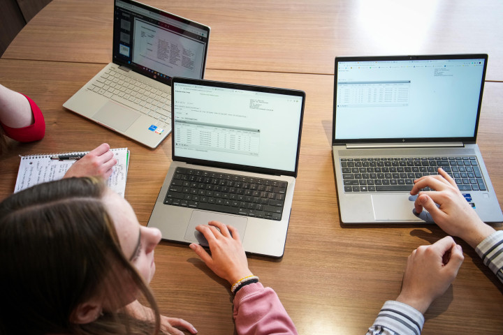 A birds-eye view of three students working on their computers