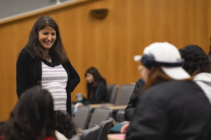 Faculty member laughing in a lecture hall