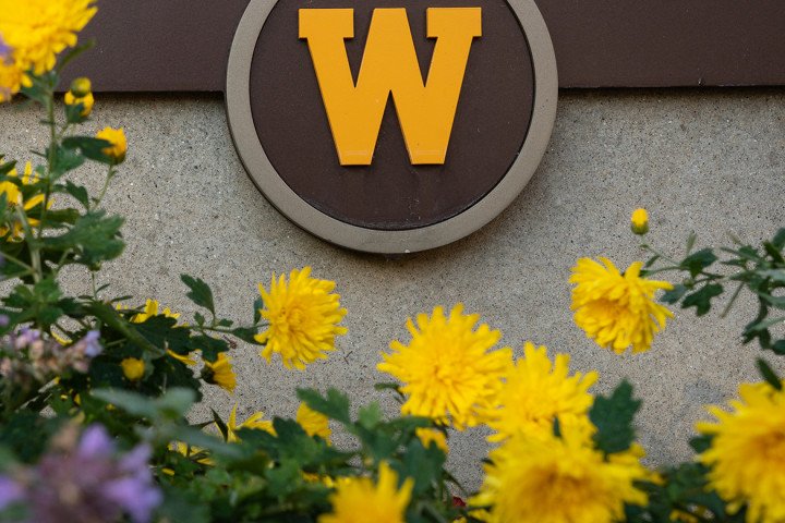 W logo on outdoor signage with flowers