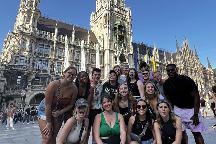 Group of business students on study abroad trip with building in the background.