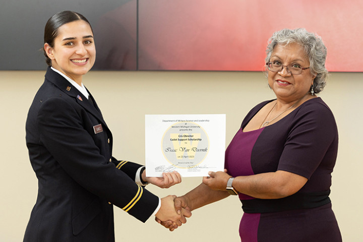Cadet receiving a scholarship certificate from a donor.