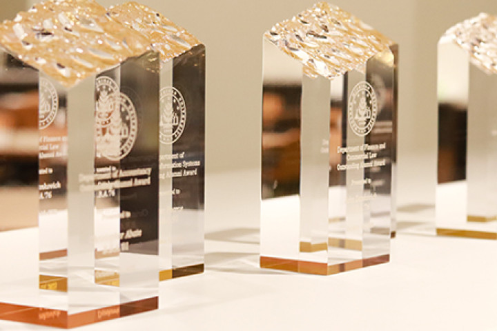 Clear glass-like awards are positioned on a table a the awards ceremony.