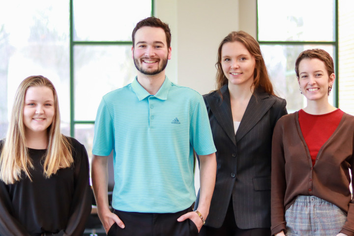 Four students who won first place the American Advertising Federation's National Student Advising Competition pose in the Dean's Conference Room.