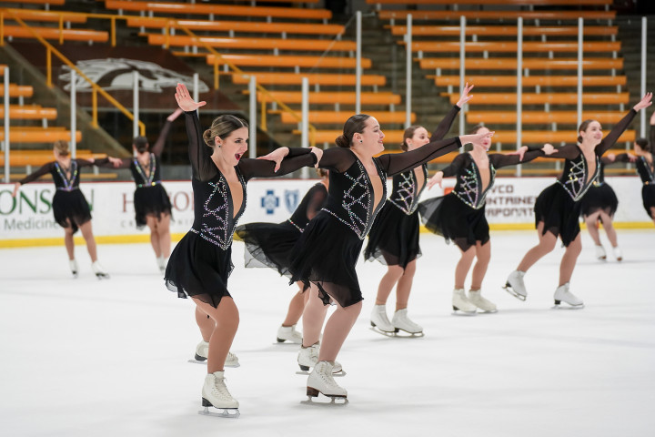 Club sports ice skaters on the ice.