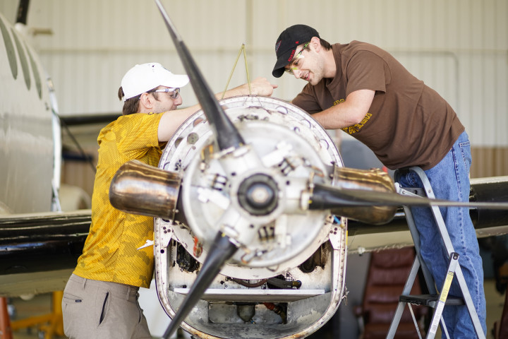 Two students working on a plane propeller.