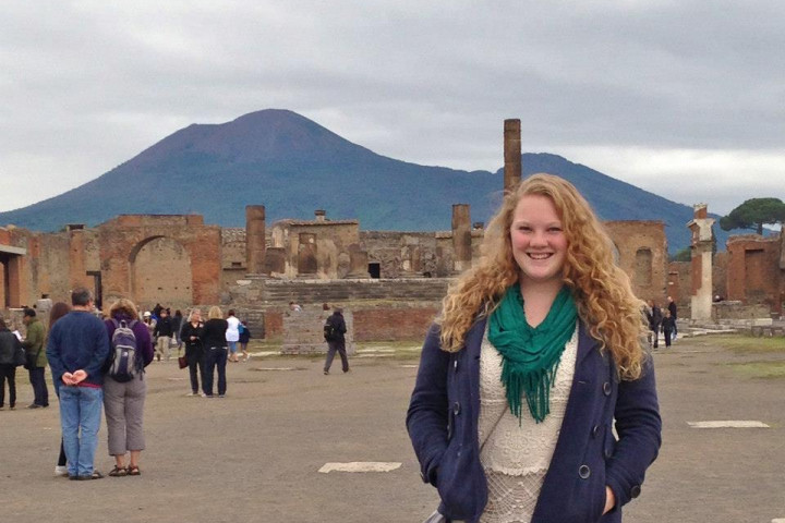 Kelly Tauschek-Hill smiling in front of ruins in Italy.