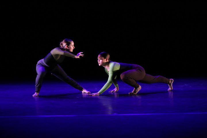 Two dancers interacting on stage.