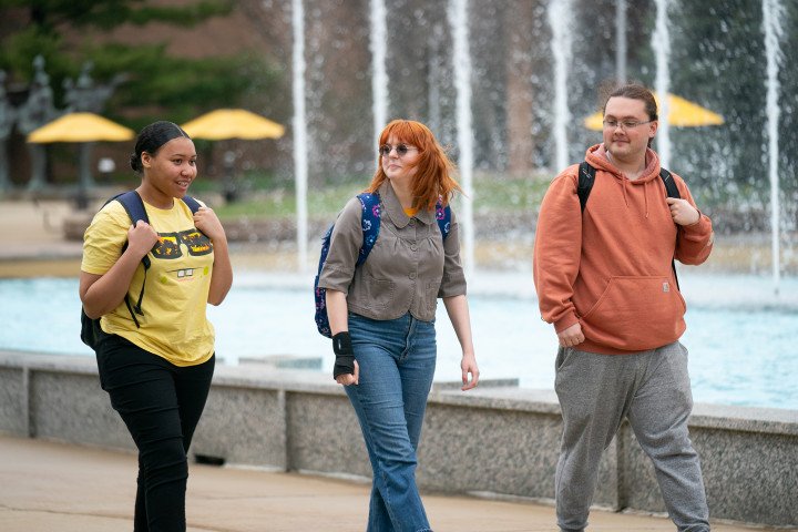 Three students walk in front of Miller Auditorium