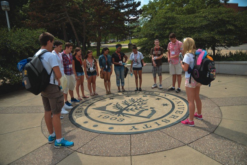 Students outside standing over the Western seal