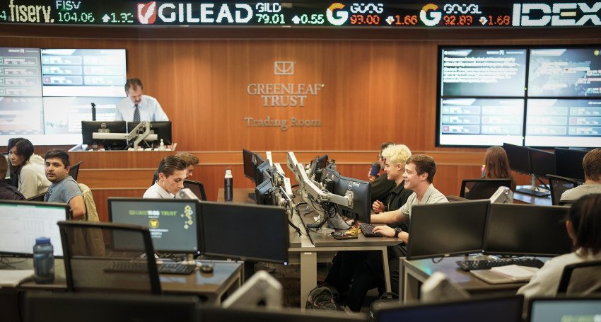 Students are in the Greenleaf Trust Trading room, taking notes.