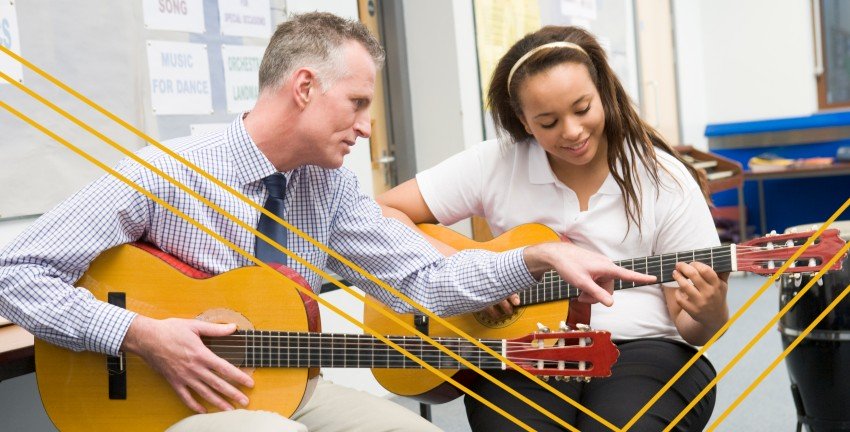 teacher teaching guitar to student