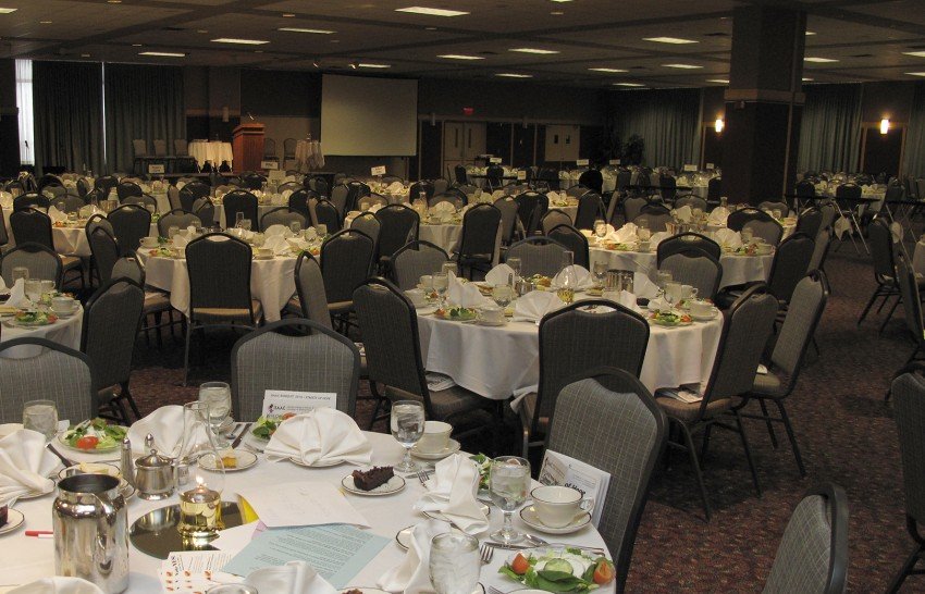 Large room with tables decorated for a meeting.