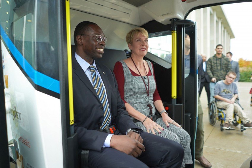 Lieutenant Governor Garlon Gilchrist sits next to Jean Ruestman as they get a ride inside the autonomous shuttle.