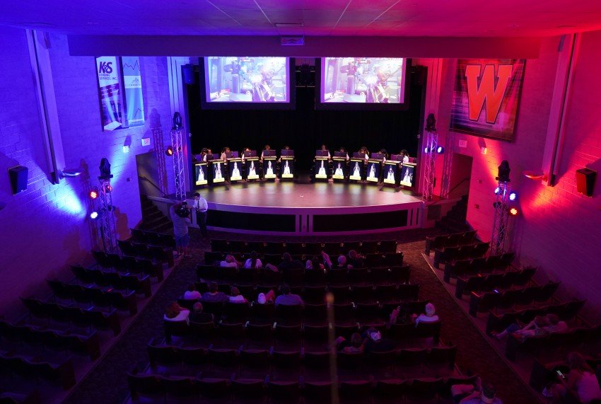 A wide view of the WMU Esports Arena lit with blue and red lights.