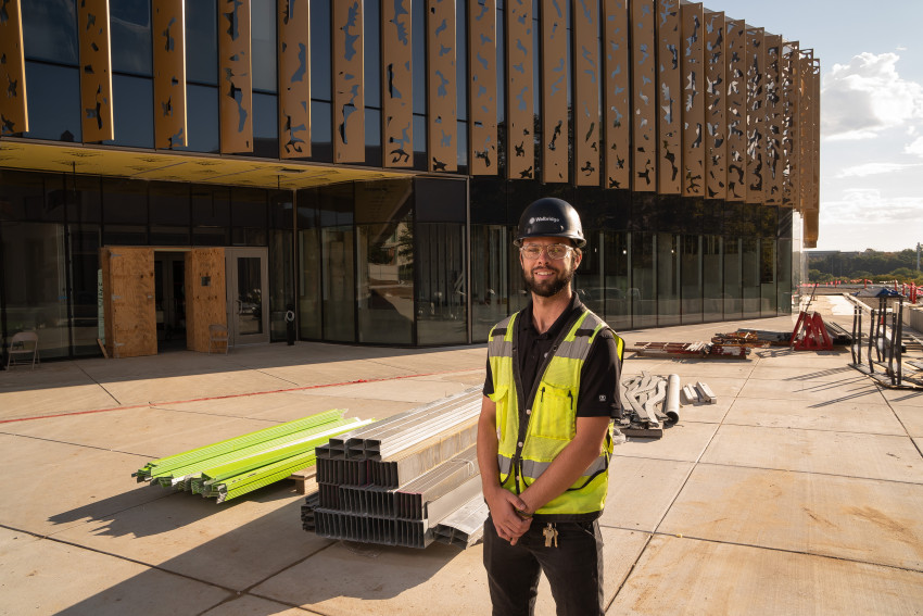Zach Turner poses in front of piles of construction equipment outside the new student center.