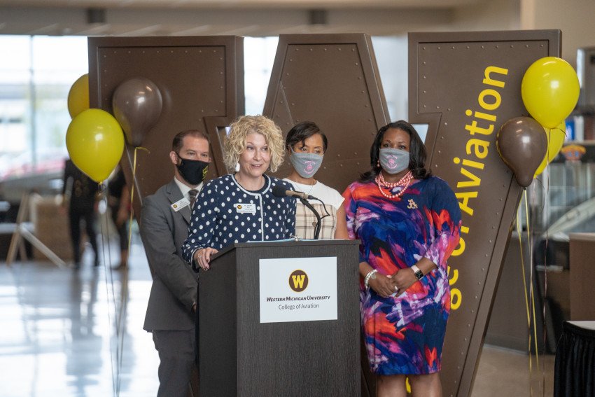 Dr. Jennifer Bott stands at a podium flanked by Dr. Ed Martini, Sonya Bernard-Hollins and Dr. Deveta Gardner.