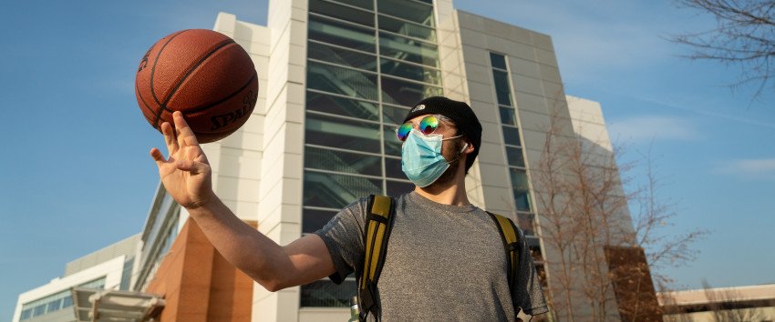 A student spins a basketball on his finger.