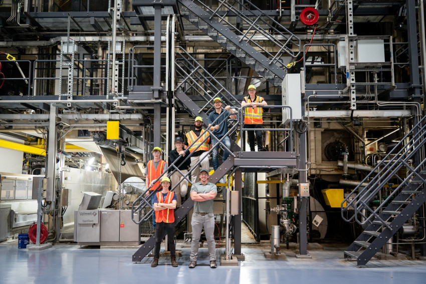 A group photo of students in an industrial setting.