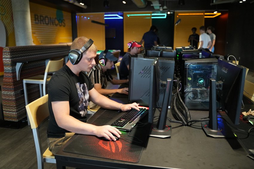 Students sit at gaming computers playing video games.
