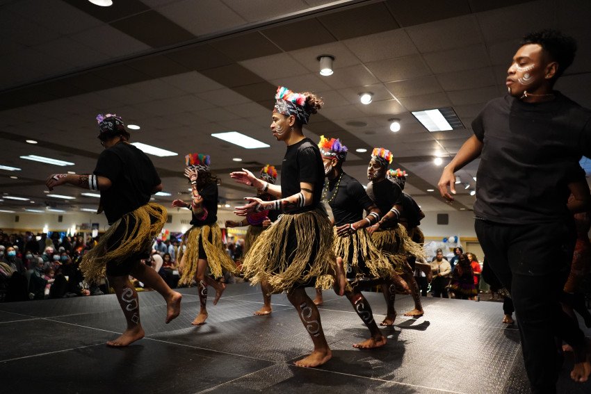 Dancers on a stage wearing grass skirts.