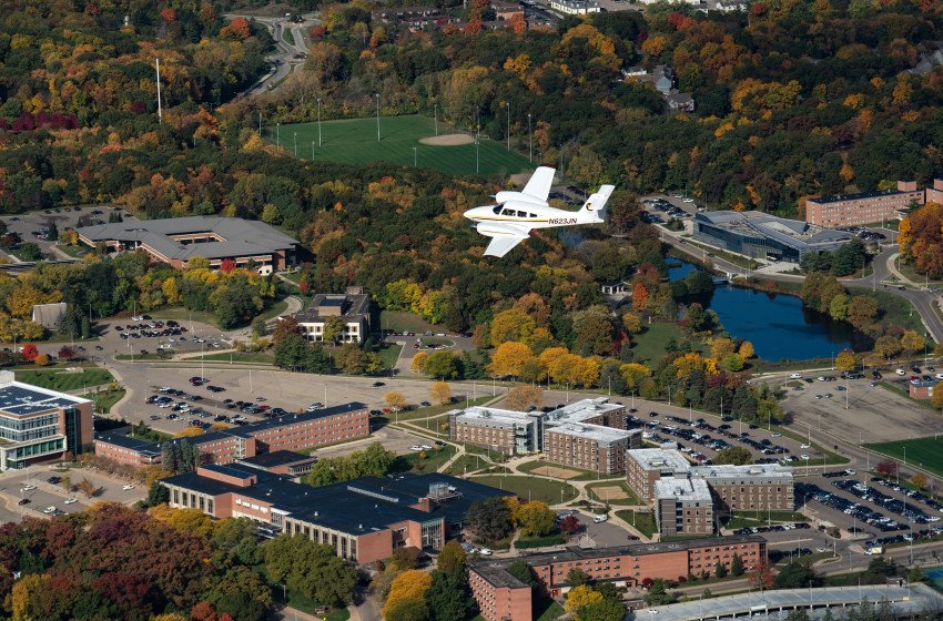 An airplane flies high in the air over Western's campus.