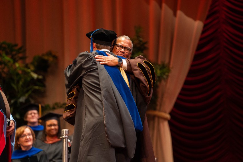 WMU President Edward Montgomery hugs a graduate.