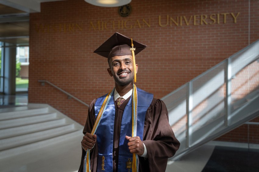 Omer Idris poses for a photo in his graduation regalia.