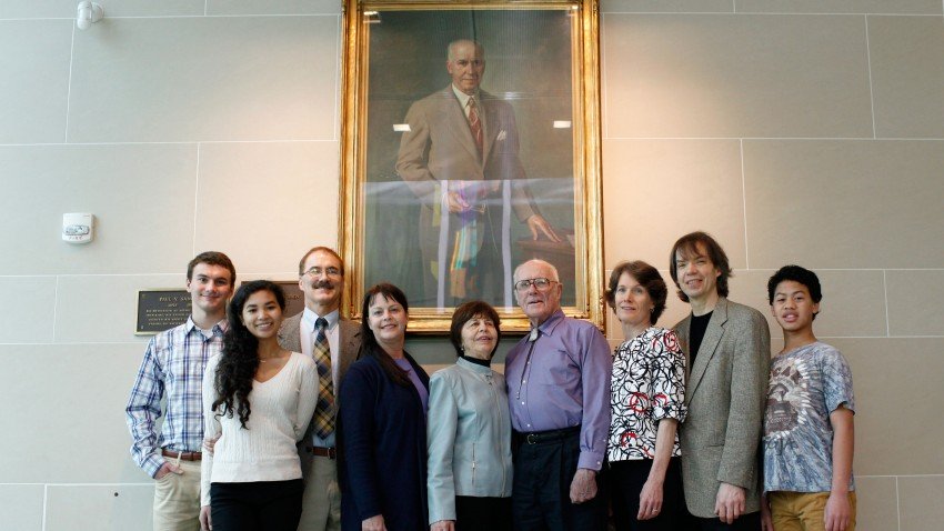 Photo of the family of Paul V. Sangren in front of his portrait.