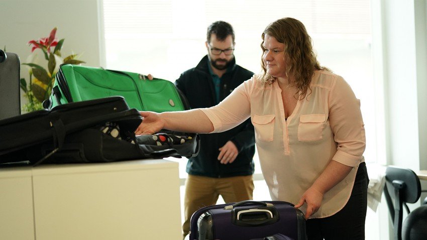 A man and woman look through donated suitcases.