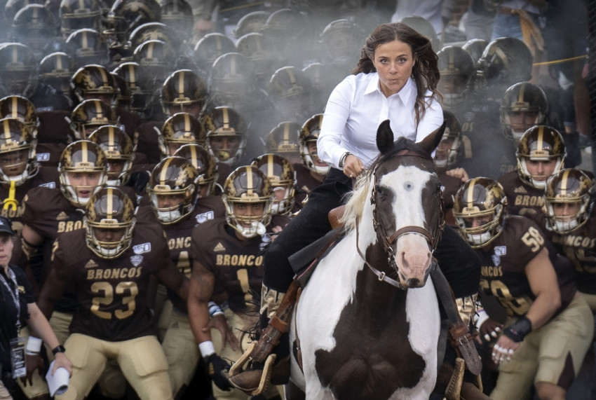 Triumph the mascot and his rider lead the WMU Bronco football team out of the tunnel at Waldo Stadium.