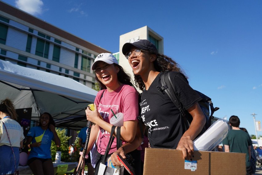 Two students smiling at Bronco Bash in front of Sangren Hall.